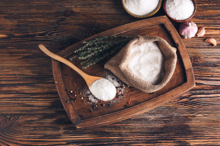 Composition with spoon and sack of salt on wooden backgroundの写真素材
