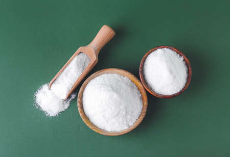 Bowls of salt on color background