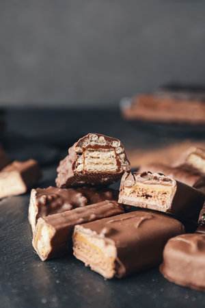 Board with cut chocolate bars on dark backgroundの写真素材