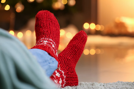 Man in warm socks near fireplace at home. Concept of heating seasonの写真素材