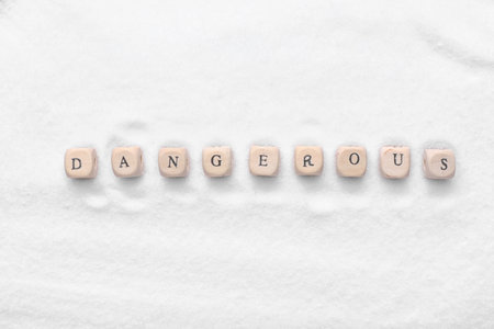 Word DANGEROUS and salt as backgroundの写真素材
