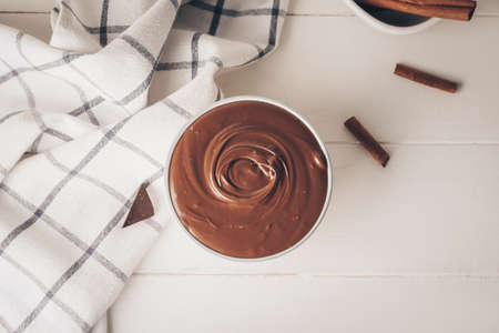 Bowl of tasty melted chocolate on light wooden backgroundの写真素材