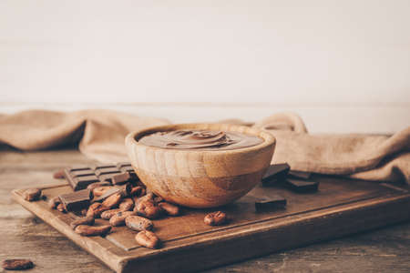 Bowl of tasty melted chocolate on wooden backgroundの写真素材