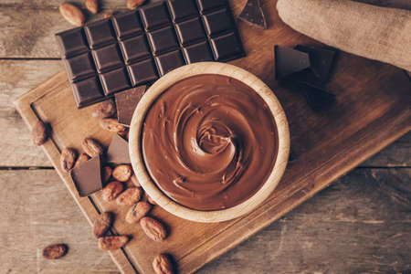 Bowl of tasty melted chocolate on wooden backgroundの写真素材