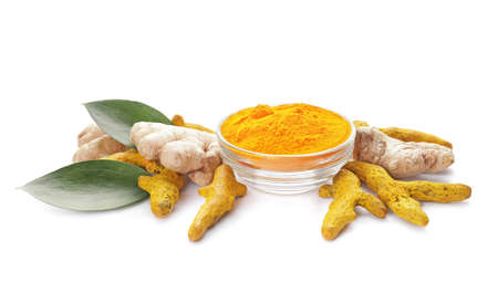 Bowl with turmeric powder and roots on white backgroundの写真素材