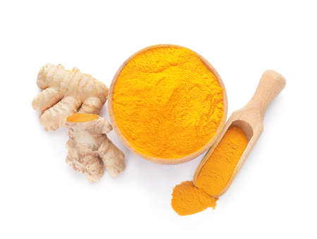 Bowl and scoop with turmeric powder on white backgroundの写真素材