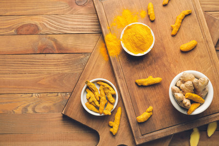 Composition with turmeric powder and roots on wooden backgroundの写真素材
