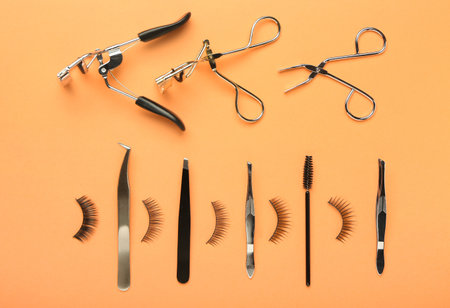 Composition with false eyelashes and tools on color background