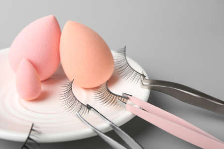 Composition with false eyelashes and tools on gray background, closeupの写真素材