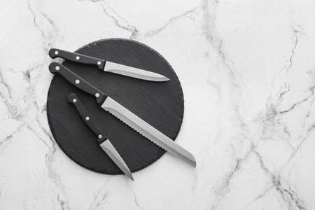 Board with set of knives on light backgroundの写真素材