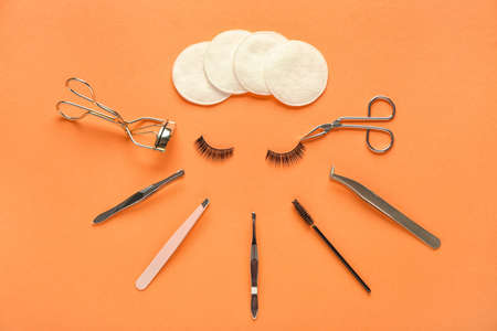 Composition with false eyelashes and tools on color backgroundの写真素材