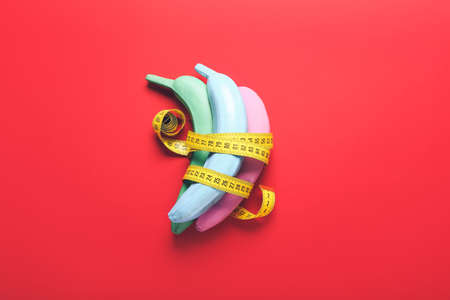 Creative composition with painted bananas and measuring tape on color backgroundの写真素材