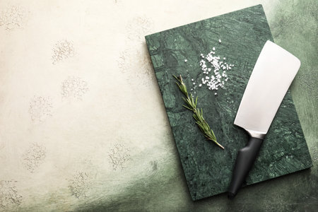 Board with knife and spices on color background