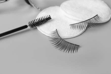 False eyelashes, cotton pads and brush on gray background, closeupの写真素材