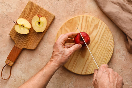 Man cutting ripe apple on color background