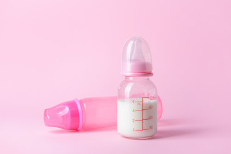 Bottles of milk for baby on color backgroundの写真素材