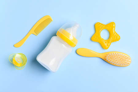 Bottle of milk for baby and accessories on color backgroundの写真素材