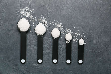Measuring spoons with salt on dark backgroundの写真素材