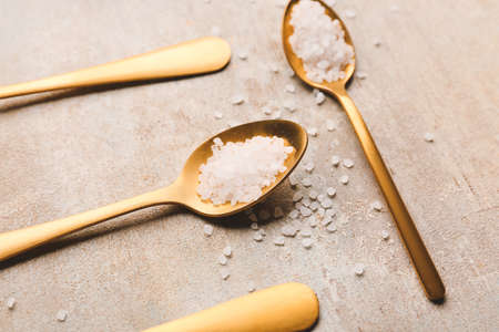 Spoons with salt on gray backgroundの写真素材