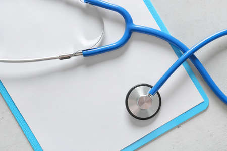 Modern stethoscope and clipboard on gray background, closeupの写真素材