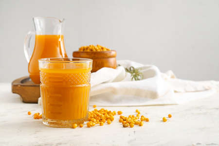 Glass of healthy sea buckthorn juice on table