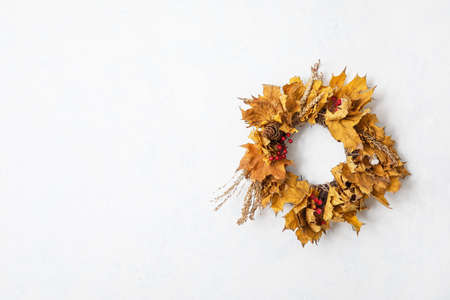 Beautiful autumn wreath hanging on white wallの写真素材