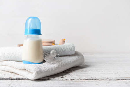 Bottle of milk for baby with accessories on table
