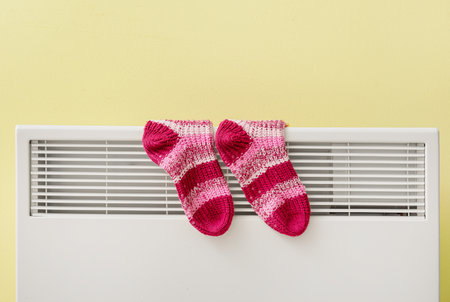 Warm socks on radiator. Concept of heating seasonの写真素材