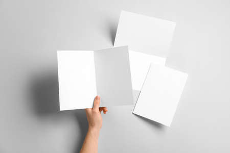 Hand with blank brochures on light backgroundの写真素材