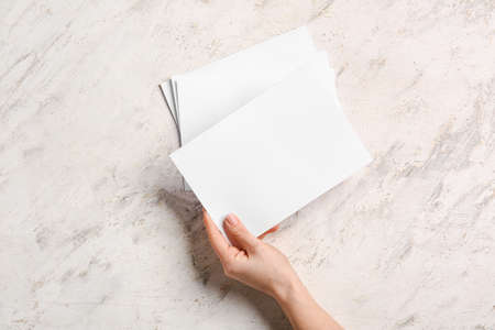 Hand with blank brochures on light backgroundの写真素材