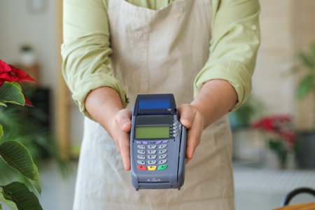 Seller with payment terminal in flower shop, closeupの写真素材