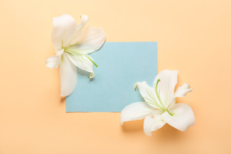Beautiful lilies and blank card on color backgroundの写真素材