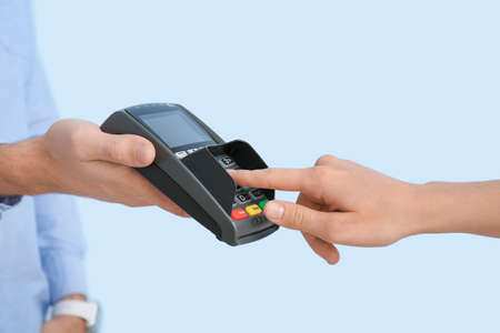 Buyer paying for purchase via terminal on color background