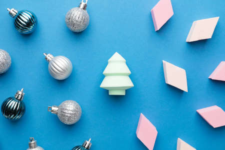 Christmas balls and makeup sponges on color background
