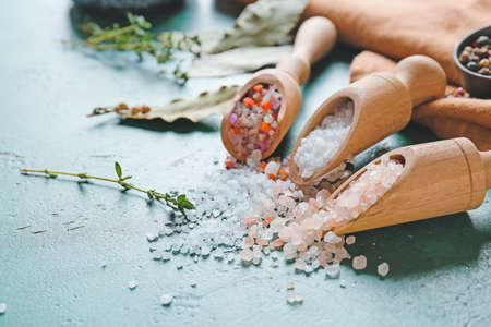 Scoops with different salt on color background, closeupの写真素材