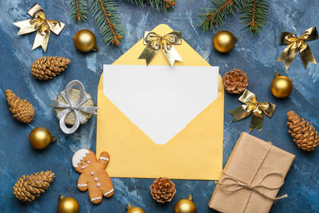 Beautiful Christmas composition with blank card and envelope on color background