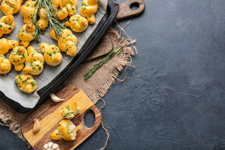 Baking sheet with tasty garlic buns on dark backgroundの写真素材