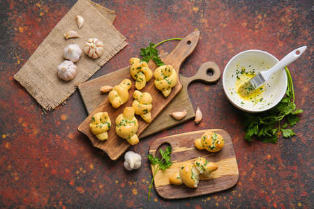 Boards with tasty garlic buns on grunge backgroundの写真素材