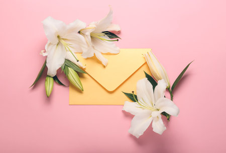 Beautiful lily flowers and envelope on color backgroundの写真素材