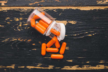 Bottle with pills on dark wooden backgroundの写真素材