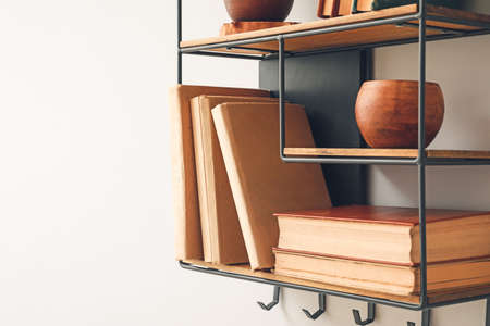 Shelf with books and decor on white wall