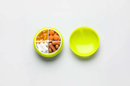 Container with different pills on light backgroundの写真素材