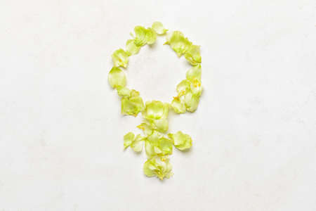 Female symbol made of flower petals on white background