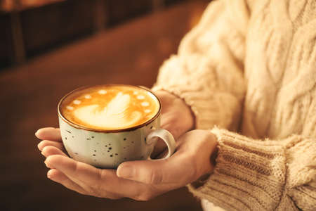 Woman with cup of latte in cafeの写真素材