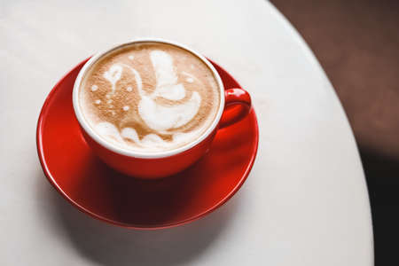 Cup of coffee with latte art on tableの写真素材