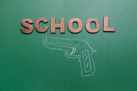 Drawn pistol on chalkboard. Concept of school shootingの写真素材
