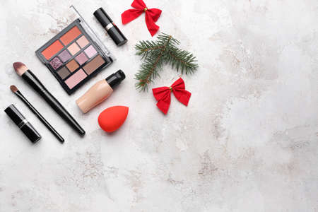 Christmas composition with cosmetics on light background