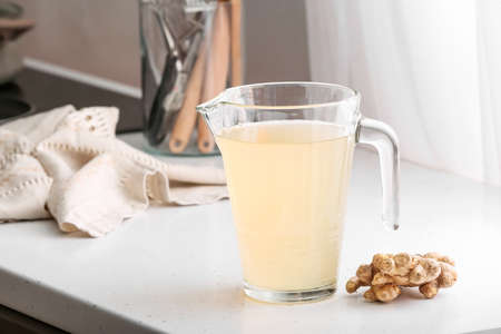 Jug of healthy ginger juice on kitchen counterの写真素材