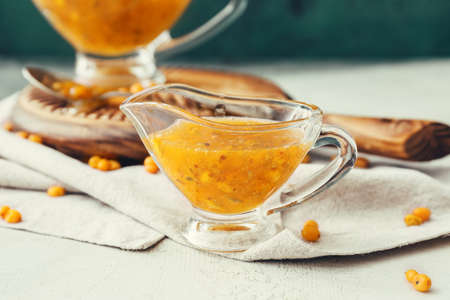 Tasty homemade sea buckthorn jam on table