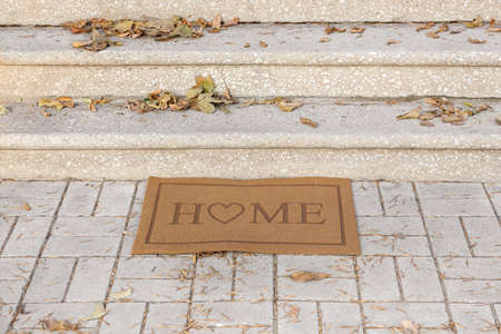 Doormat near entrance of house on autumn day
